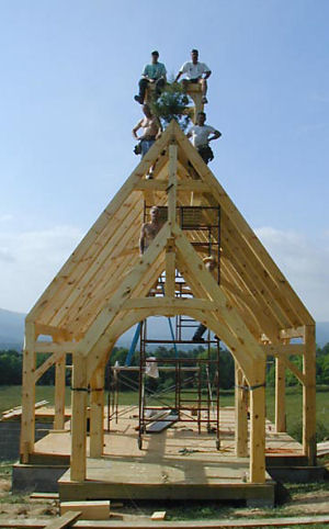 Timber framers atop a newly completed chapel frame
